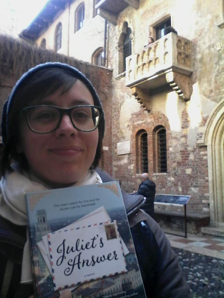 Anna con il libro Juliet's Answer in mano, sotto il balcone di Giulietta